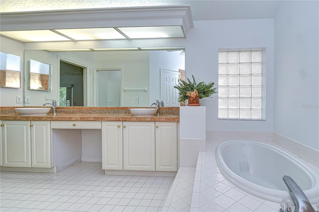 bathroom with double vanity, a sink, and a bath