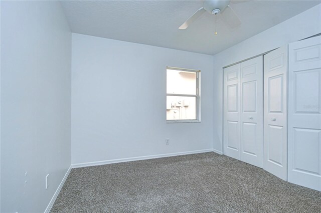 unfurnished bedroom with carpet, a closet, ceiling fan, a textured ceiling, and baseboards