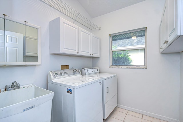 laundry room featuring cabinet space, baseboards, separate washer and dryer, a sink, and light tile patterned flooring