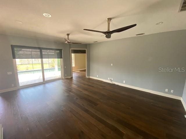 spare room featuring recessed lighting, dark wood-type flooring, visible vents, a ceiling fan, and baseboards