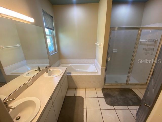 bathroom featuring tile patterned flooring, a sink, and a bath