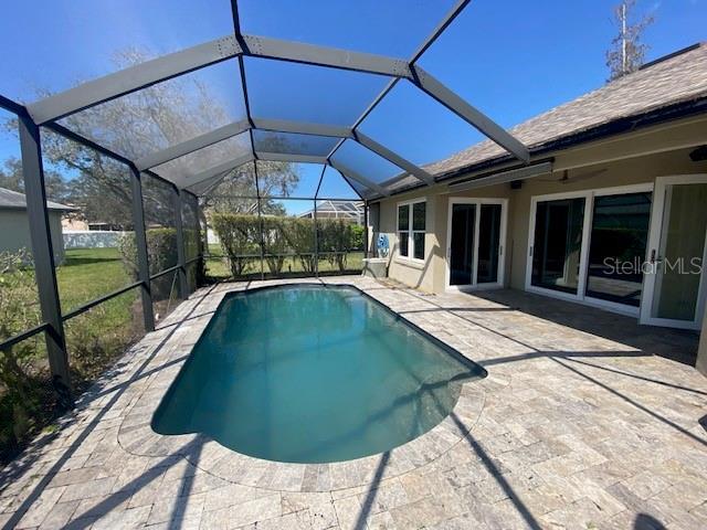 pool with a patio and glass enclosure