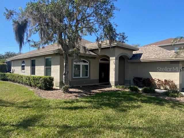 single story home featuring a front yard and stucco siding