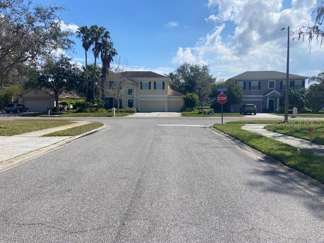 view of street with traffic signs, a residential view, sidewalks, and street lights