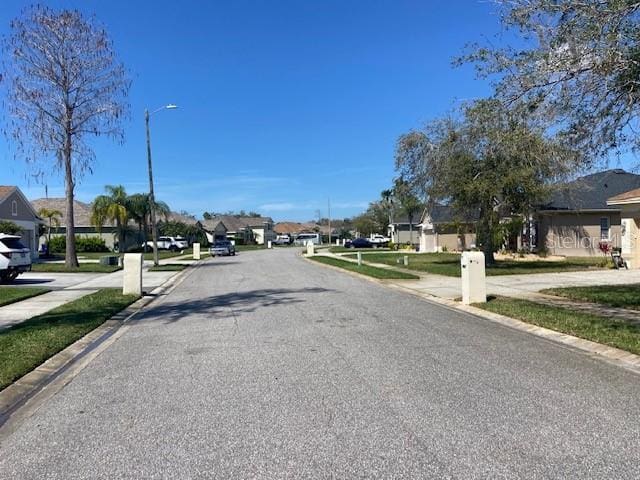 view of street featuring sidewalks, street lighting, a residential view, and curbs