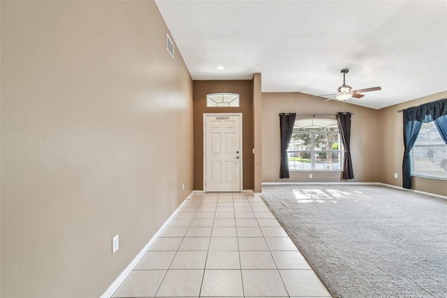 foyer with light carpet, visible vents, vaulted ceiling, and a wealth of natural light