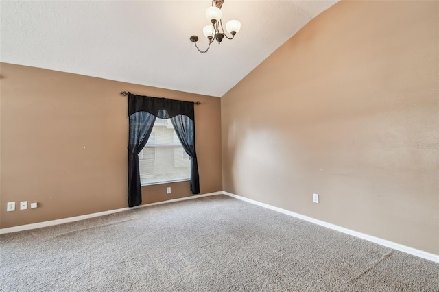 carpeted spare room with lofted ceiling, a notable chandelier, and baseboards