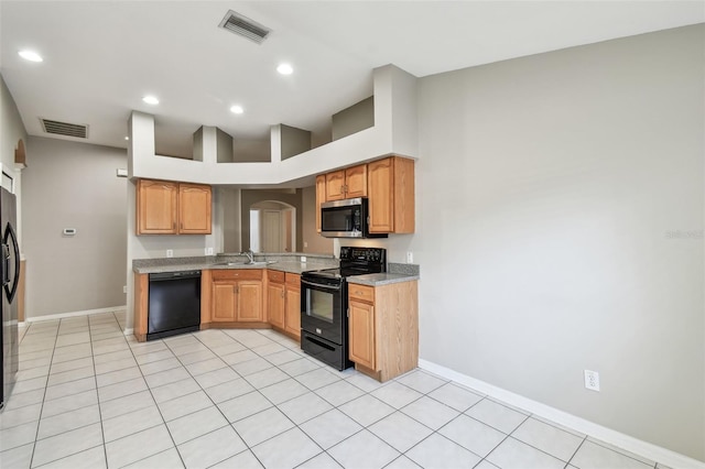 kitchen featuring black appliances, visible vents, arched walkways, and a sink