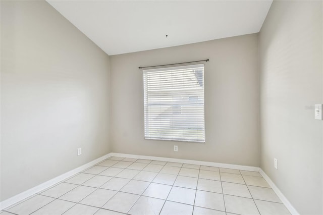 unfurnished room featuring vaulted ceiling, baseboards, and light tile patterned floors