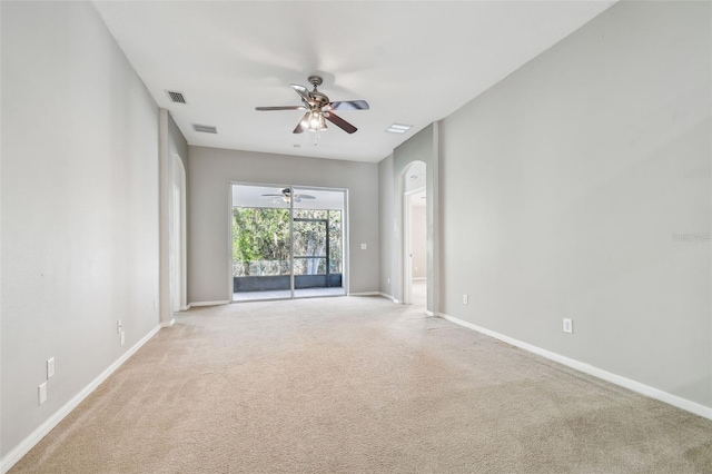 carpeted empty room featuring a ceiling fan, visible vents, and baseboards