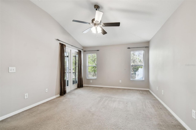 unfurnished room featuring a ceiling fan, lofted ceiling, light colored carpet, and baseboards