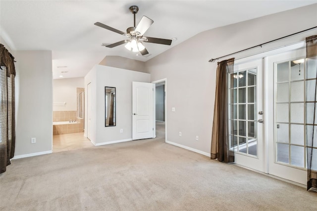 unfurnished bedroom with baseboards, ensuite bath, vaulted ceiling, french doors, and carpet floors