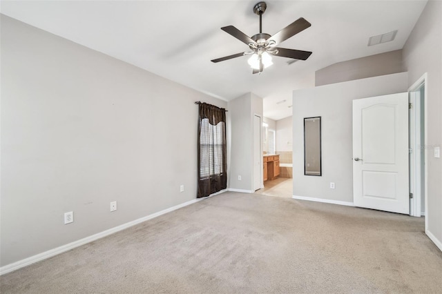 unfurnished bedroom with vaulted ceiling, carpet, visible vents, and baseboards