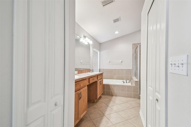 bathroom featuring a garden tub, visible vents, vaulted ceiling, vanity, and tile patterned flooring