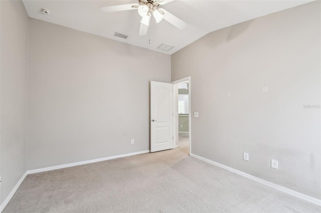 spare room with baseboards, visible vents, light colored carpet, lofted ceiling, and ceiling fan