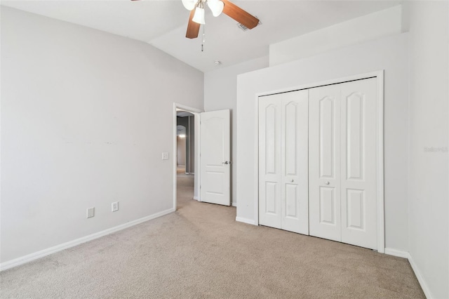 unfurnished bedroom with carpet floors, lofted ceiling, a closet, a ceiling fan, and baseboards