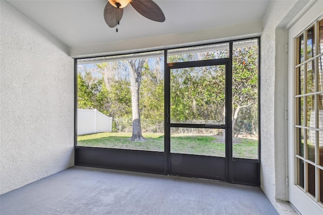 unfurnished sunroom featuring ceiling fan