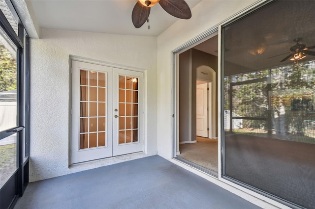 unfurnished sunroom with a ceiling fan and french doors