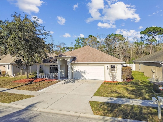 ranch-style home with driveway, stucco siding, roof with shingles, an attached garage, and a front yard