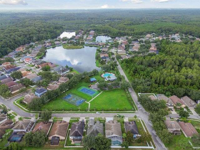 drone / aerial view with a water view, a residential view, and a wooded view