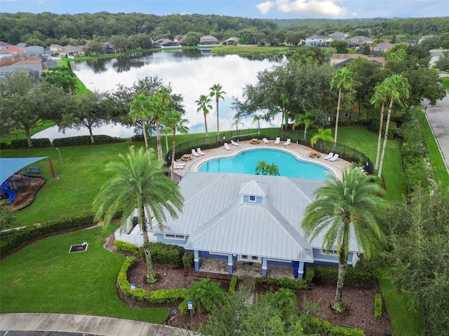 pool featuring a water view, fence, and a yard