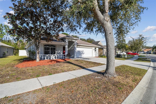 view of front of home featuring driveway, a garage, a front lawn, and stucco siding