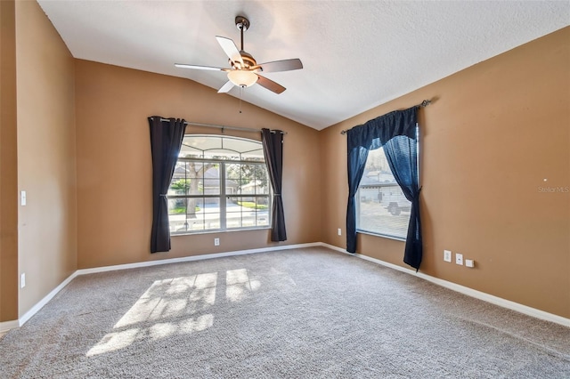 unfurnished room featuring baseboards, a ceiling fan, lofted ceiling, a textured ceiling, and carpet floors