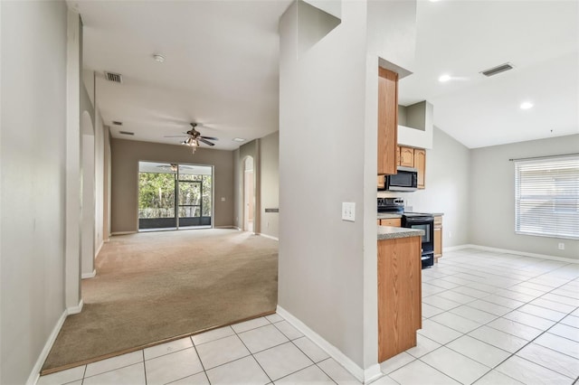 kitchen with open floor plan, stainless steel microwave, black range with electric stovetop, and visible vents