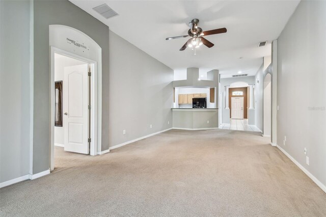 unfurnished living room with light carpet, baseboards, visible vents, and a ceiling fan