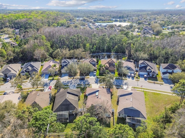 drone / aerial view featuring a residential view and a wooded view