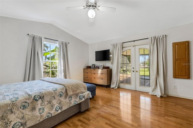 bedroom featuring lofted ceiling, access to outside, wood finished floors, and french doors