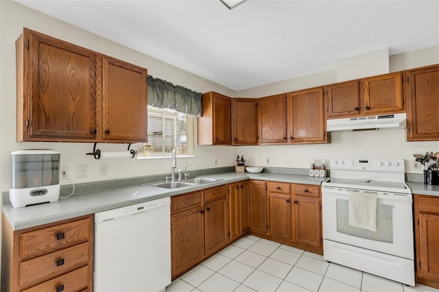 kitchen with under cabinet range hood, white appliances, a sink, light countertops, and brown cabinetry