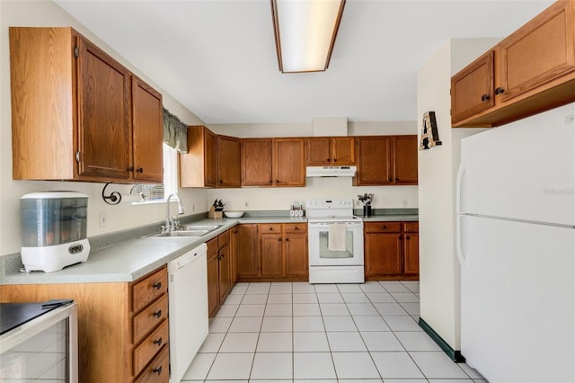 kitchen with brown cabinets, light countertops, a sink, white appliances, and under cabinet range hood