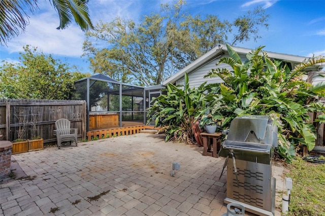 view of patio / terrace featuring a lanai, a grill, and fence