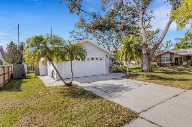 view of side of property with a detached garage, fence, and a yard