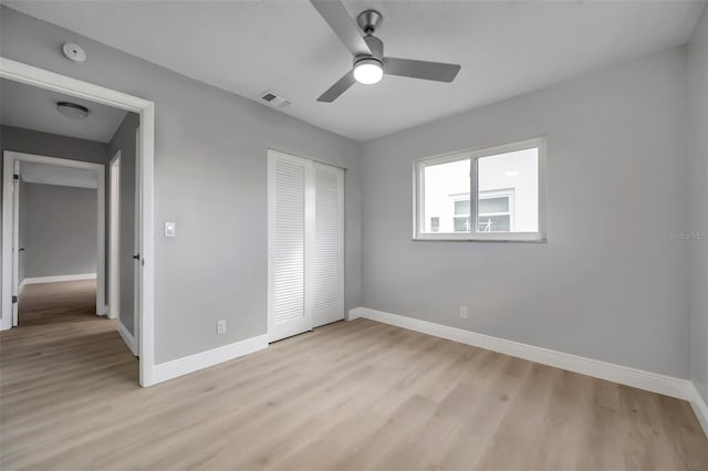 unfurnished bedroom with a closet, light wood finished floors, and baseboards