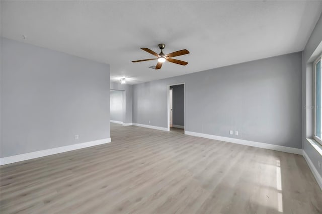 empty room featuring baseboards, ceiling fan, and light wood-style floors