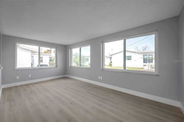 empty room with light wood-type flooring and baseboards