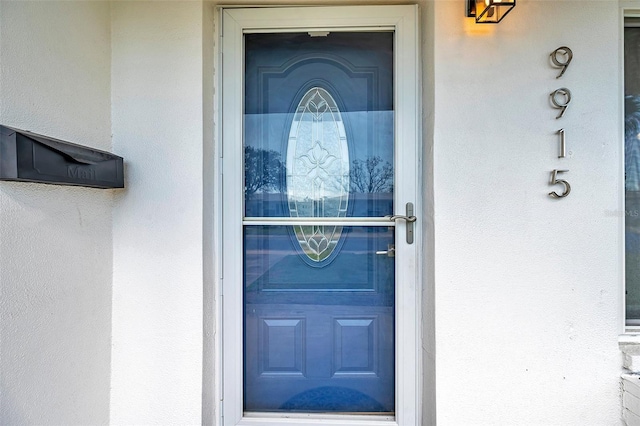 entrance to property featuring stucco siding