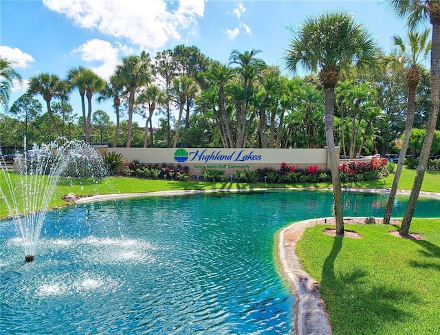 view of swimming pool with a water view and a yard