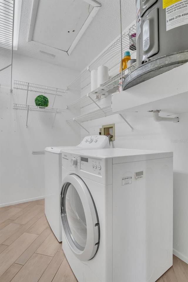 laundry area with laundry area, independent washer and dryer, light wood-style flooring, and baseboards