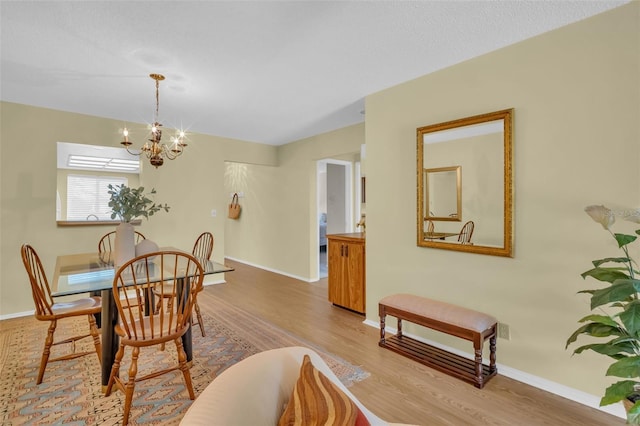 dining area with an inviting chandelier, baseboards, and wood finished floors