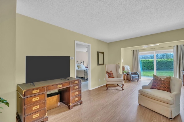 office featuring a textured ceiling, baseboards, and light wood-style floors