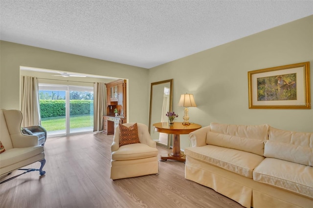 living area with a textured ceiling and wood finished floors