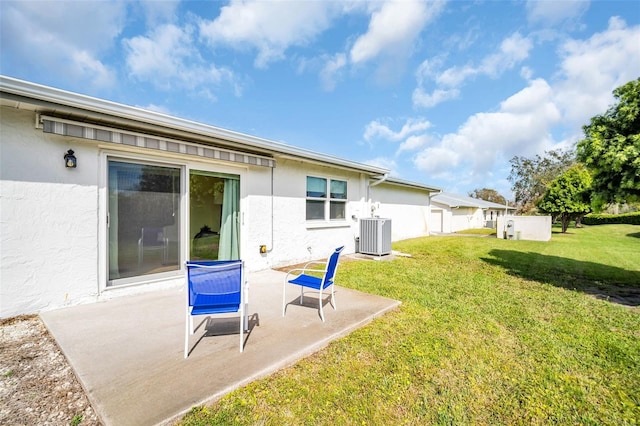 back of property featuring a patio area, central AC, a lawn, and stucco siding