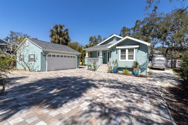 view of front of house with a garage, covered porch, and decorative driveway