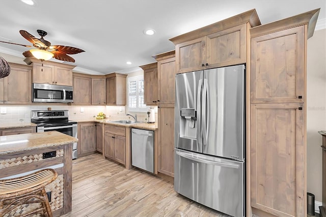 kitchen with light stone counters, stainless steel appliances, decorative backsplash, ornamental molding, and a sink