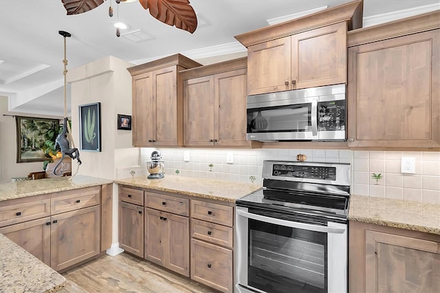 kitchen featuring ceiling fan, stainless steel appliances, light wood finished floors, and decorative backsplash