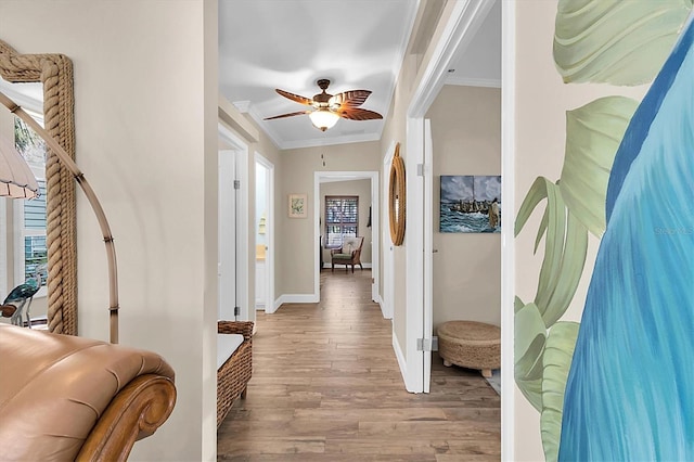 interior space with baseboards, wood finished floors, and crown molding