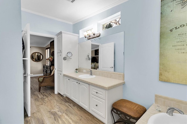 bathroom with ornamental molding, wood finished floors, and vanity